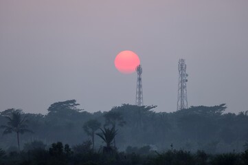 The sun setting behind a cell tower.this photo was taken from khulna,Bangladesh. - Powered by Adobe