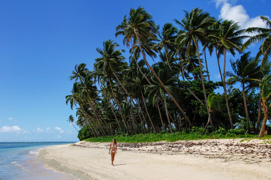 Young woman in bikini walking on a beach in Lavena village on Taveuni Island, Fiji