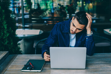 caucasian millennial man working on freelance using netbook and wireless internet