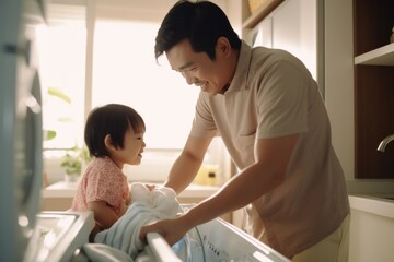 Father and Son Doing Laundry Together to load the washing machine with dirty clothes