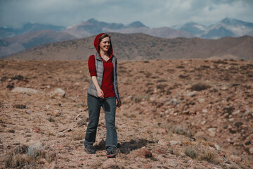 Fototapeta premium Young smiling woman tourist walks in the mountains