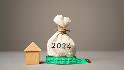 Wooden house and money bag 2024. Family budget planning for next year. Investments, plans, savings....