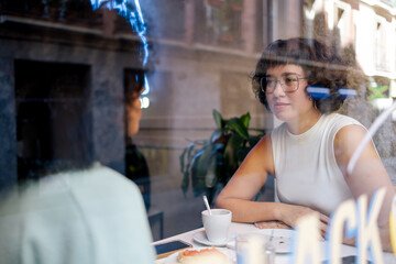 Two diverse friends having breakfast in cafeteria