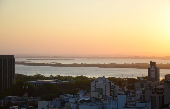 Aerial view of the central area of Porto Alegre with the Guaiba River in the background - clear sky sunset © Matheus