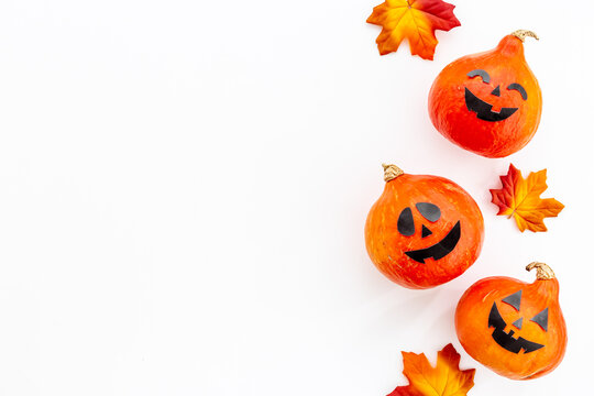 Halloween holiday background with pumpkin head and dry leaves, top view