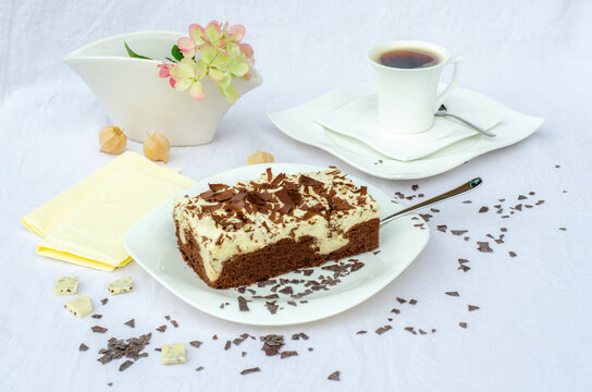 Stracciatellakuchen mit Schokoladenspänen auf Schokoladenboden und Kaffeegedeck