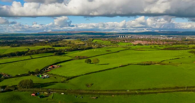 Hyper-Lapse video of Tandle Hill landscape showing green fields and sheep grazing with fast moving clouds. Beautiful Vista