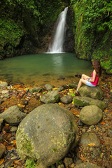 Young woman siting at Seven Sisters Falls, Grenada island, Grenada.