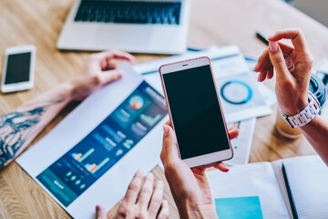 Employees browsing cellphone and checking documents