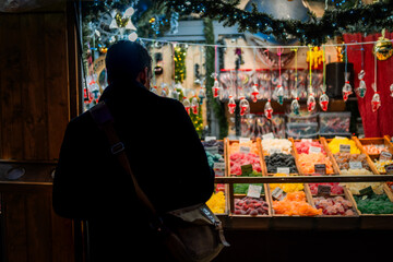 Young man with handbag looking at a Christmas market