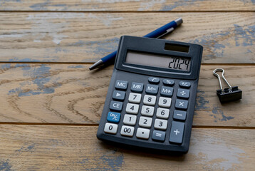 Calculator with the number 2024 on the display and stationery. Concept of finance, taxes, savings...