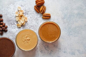 Homemade nuts butter in a glass jars with various nuts.
