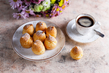 Homemade profiteroles with powdered sugar.