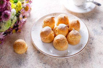 Homemade profiteroles with powdered sugar.