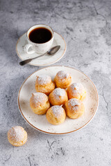 Homemade profiteroles with powdered sugar.