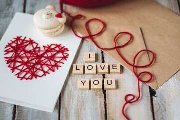 Beautiful wooden letterI love you on wooden background. Lovely cute handmade greeting card with red heart embroidering for Mothers or Saint Valentine's day, wedding or anniversary - obrazy, fototapety, plakaty