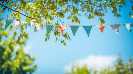 string of colorful pennant against blue sky in the garden as a summer party decoration - obrazy, fototapety, plakaty