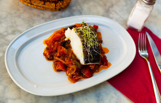 Popular dish of Spanish cuisine is Bacala, made from fish with vegetables and decorated with greenery on top