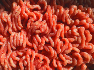 A detailed close-up shot of fresh, pink ground meat with visible texture and strands no GMO or preservatives added