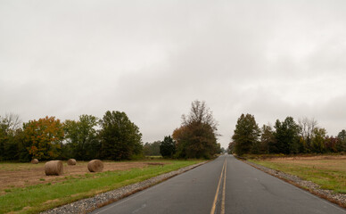 Road passing through farm filed on moody autumn morning in rural New Jersey