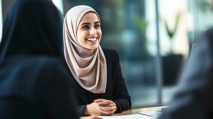 smiling middle eastern business woman with hijab talking with client - obrazy, fototapety, plakaty