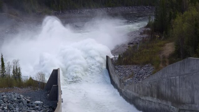Hydroelectric dam on the river, powerful water discharge from the reservoir at Ajaureforsen, Northern Sweden. Top down close up view from the dam.