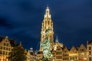 Fototapeta na wymiar Brabo-Brunnen auf dem Grote Markt in Antwerpen, umgeben von Gilde- und Zunfthäusern und im Hintergrund die Liebfrauenkathedrale – Nachtaufnahem