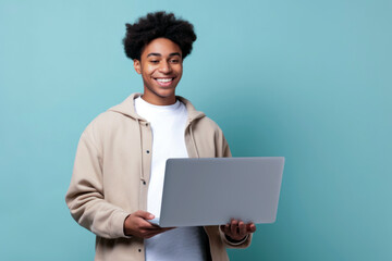 happy young african man holding laptop over a blue background