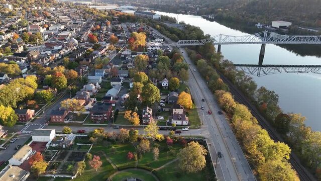 A high early evening aerial establishing shot view of a small New England river town. Pittsburgh suburbs.  	