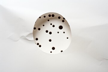 Abstract holes punched in the white paper sheet