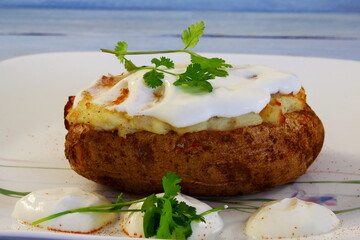 fresh Stuffed baked potatoes garnish or topping with green coriander,cream cheese spice and cheese