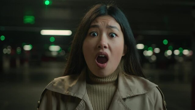 Close up shocked confused frightened Asian chinese korean woman girl at night underground shelter parking feel panic suffer stress fright amazed afraid scare face open mouth unexpected shock emotion