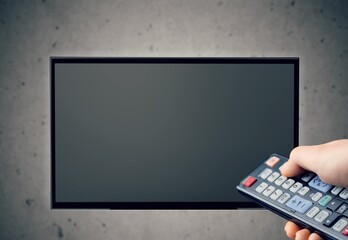 Person turns on TV set with remote control. .