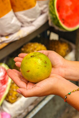 dulce naranja sostenida con las manos lista para su compra o veta en el mercado