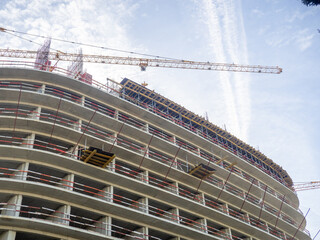 Fototapeta premium Construction of a modern high-rise building. Sides on the floors. Concrete frame of a building under construction. Construction in progress