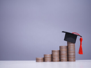 Graduation hat on stack of coins. The concept of saving money for education, student loan, scholarship, tuition fees in future