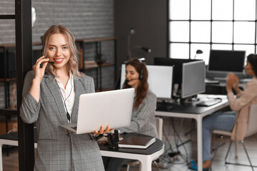 Female technical support agent with laptop in office