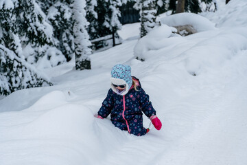 Fototapeta na wymiar Little girl playing in a deep snow