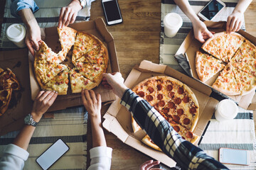 People taking slices of pizza on box at table - obrazy, fototapety, plakaty