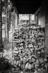 Piles of cut and split firewood, ready for winter, piled behind a mountain house.  Black and White Image.  Whistler BC, Canada.