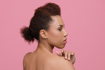 Beautiful young woman with glamorous makeup on pink background