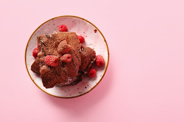 Plate with pieces of raspberry chocolate brownie on pink background - obrazy, fototapety, plakaty