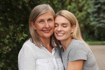 Happy mature mother and her daughter outdoors