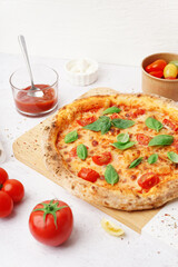 Board of tasty pizza Margarita with basil on white table