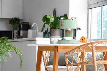 Modern coffee machine and croissant on white table in kitchen