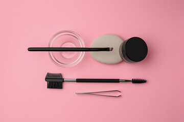 Eyebrow henna and professional tools on pink background, flat lay