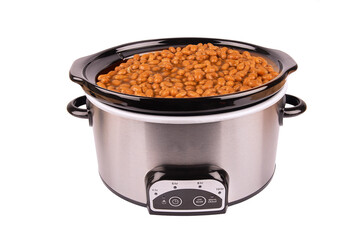 Beans cooking in a stainless crock pot isolated on a white background, cut out. - 666837563