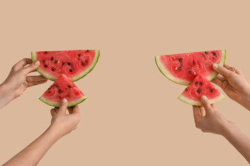 Female hands with slices of ripe watermelon on beige background