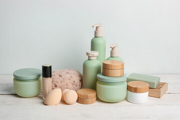 Set of cosmetic products and bath supplies on light wooden table