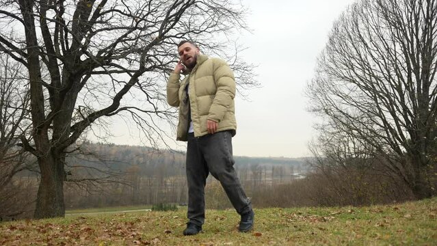 Portrait of positive young man singing rap and gesturing in park